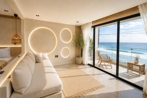 A modern living room with a large sofa, a dining table, and a view of the ocean. - Water-front Luxury + King Bed w/AC (Tijuana)