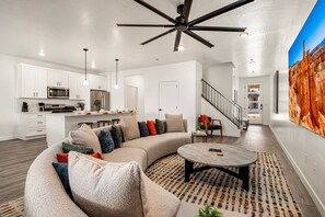 A modern living room with a sectional sofa, a coffee table, and a ceiling fan. - Skyline 3 Homes Retreat, Private Swim Spas, SLP 48 (Washington)