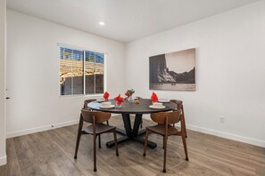 A dining area with a round table, four chairs, and a painting on the wall. - Skyline 3 Homes Retreat, Private Swim Spas, SLP 48 (Washington)