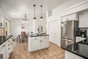A kitchen with white cabinetry, a stainless steel refrigerator, and a central island with a sink. - 3819, Private Pool, Private Spa, BBQ, Outdoor Fire Pit, Xbox 1 (Hurricane)