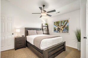 A bedroom with a bed, bedside tables, a ceiling fan, a window with a view, and a door. - 3819, Private Pool, Private Spa, BBQ, Outdoor Fire Pit, Xbox 1 (Hurricane)