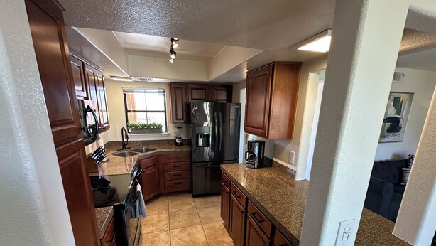 A kitchen with granite countertops, stainless steel appliances, and wooden cabinets. - Foothills gem! (Tucson)