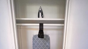 Um quarto com uma porta, uma parede e uma prateleira, tudo em branco.