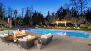 A swimming pool with a fire pit and outdoor seating area.