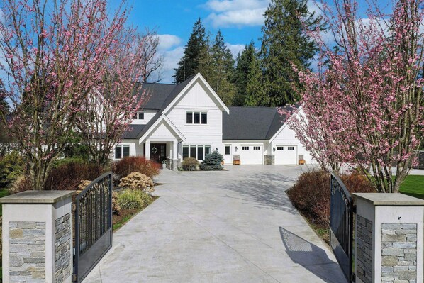 A two-story house with a front driveway leading to a garage.