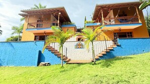 A two-story building with a blue exterior and a central staircase leading to a balcony.
