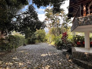 Un sendero de piedra que conduce a un edificio con fachada de piedra y un balcón.