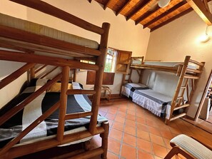 Una habitación rústica con literas de madera, un sofá y una silla.