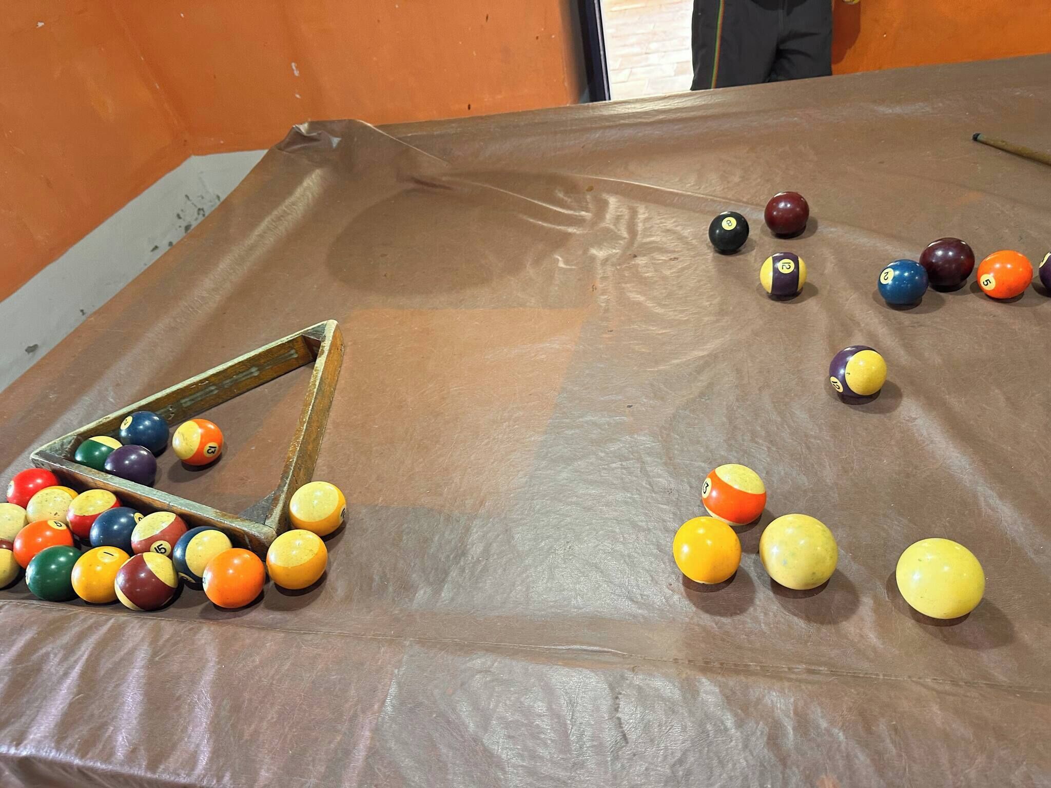 A pool table with balls scattered across it.