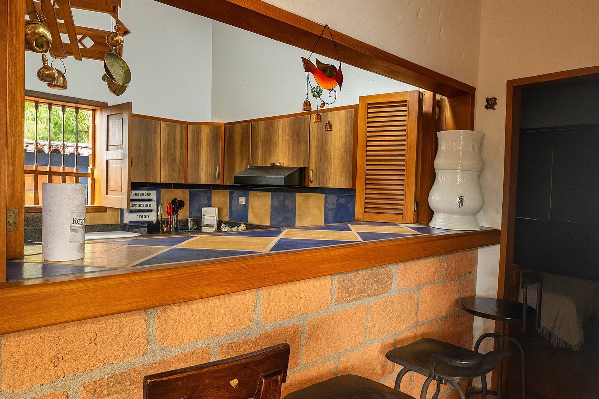 A kitchen with wooden cabinets, a tiled backsplash, and a hanging light fixture.