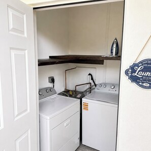 A laundry room with two washers and dryers, a water heater, and a sign indicating a self-service room. - Coconut Grove Area - Twin Homes - Sleeps 12 (Miami)