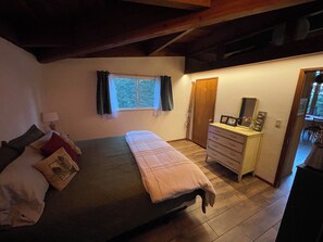 A bedroom with a bed, dresser, window, and a door leading to another room. - Mid-Century Tahoe Vibes, Peeks of Lake Tahoe, Trails & National Forest out back (Carnelian Bay)