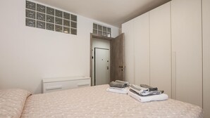 A bedroom with a bed, a dresser, a window, and a door. - Cozy apartment in Carro with WiFi (Carro)