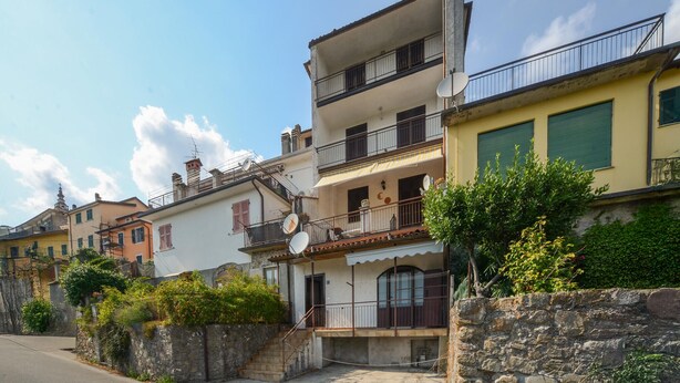 A row of Mediterranean-style buildings with balconies, stone walls, and a clear sky. - Cozy apartment in Carro with WiFi (Carro)