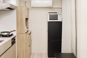 Uma cozinha compacta com micro-ondas, geladeira e fogão.