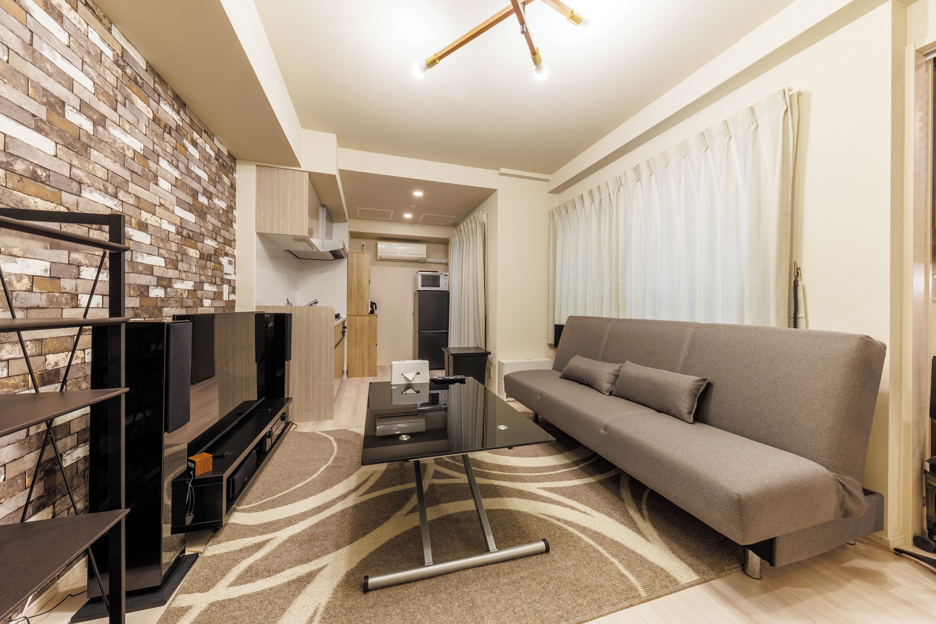 A modern living room with a sofa, a coffee table, and a TV stand.