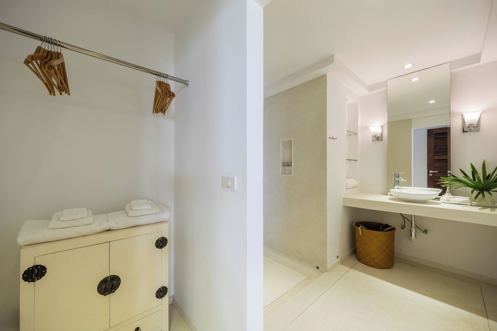 A modern bathroom with a white vanity, a large mirror, and a sink.