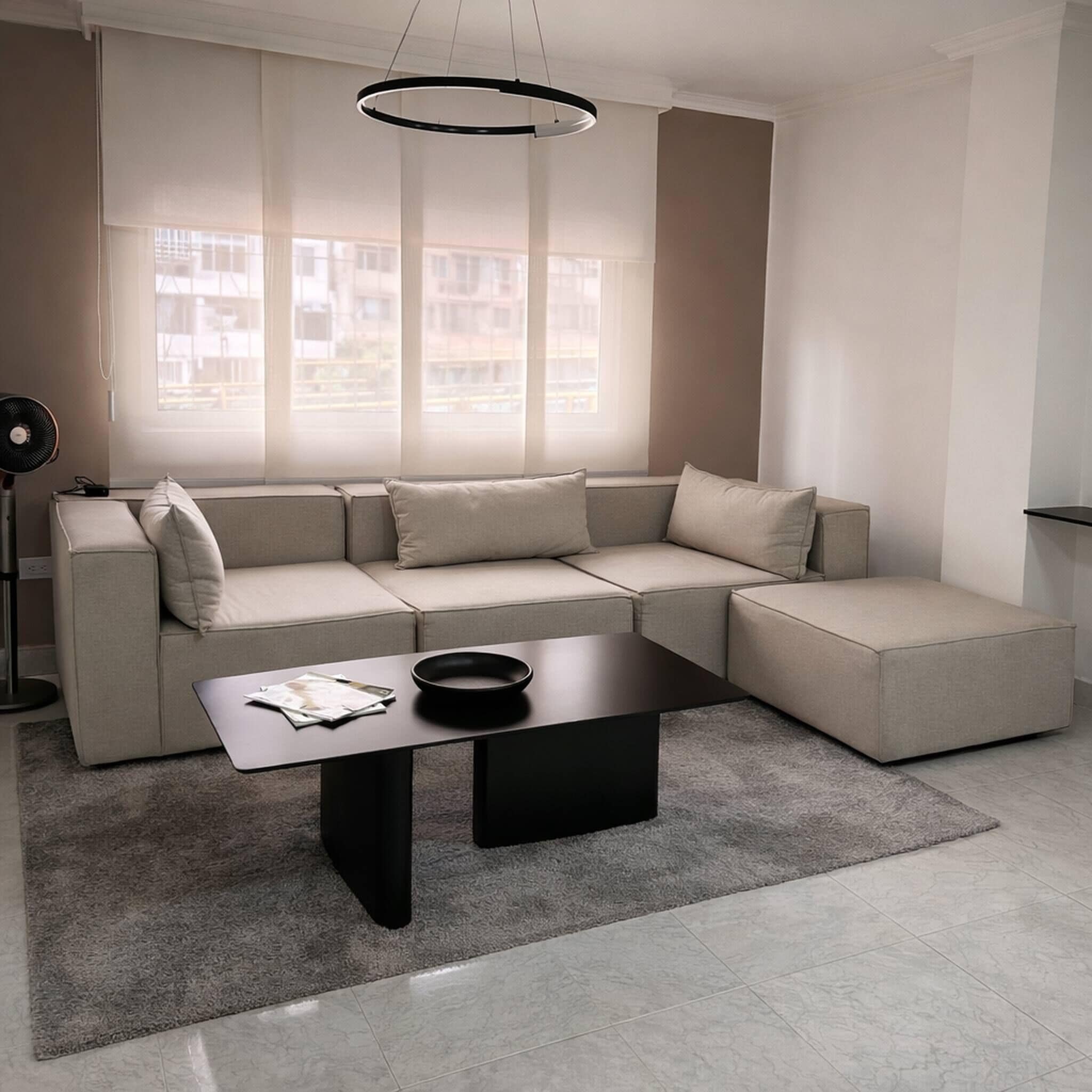 Ein modernes Wohnzimmer mit einer Eckcouch, einem Couchtisch und einer Stehlampe.