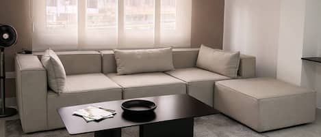 A modern living room with a sectional sofa, a coffee table, and a floor lamp.