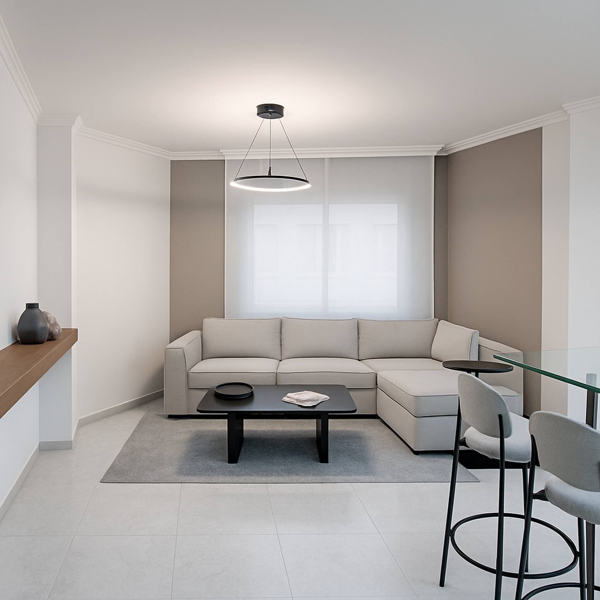 Een moderne woonkamer met een hoekbank, een salontafel met glazen blad en een hanglamp.