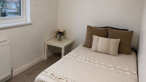 A bedroom with a bed, a nightstand, a window, and a ceiling light. - Room 3 2 Twickenham Gardens London (Greenford)