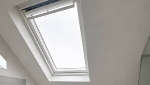A modern bathroom with a skylight, a shower, and a toilet. - Spacious Room Perfect for Contractors Couples Solo Travellers (Greenford)