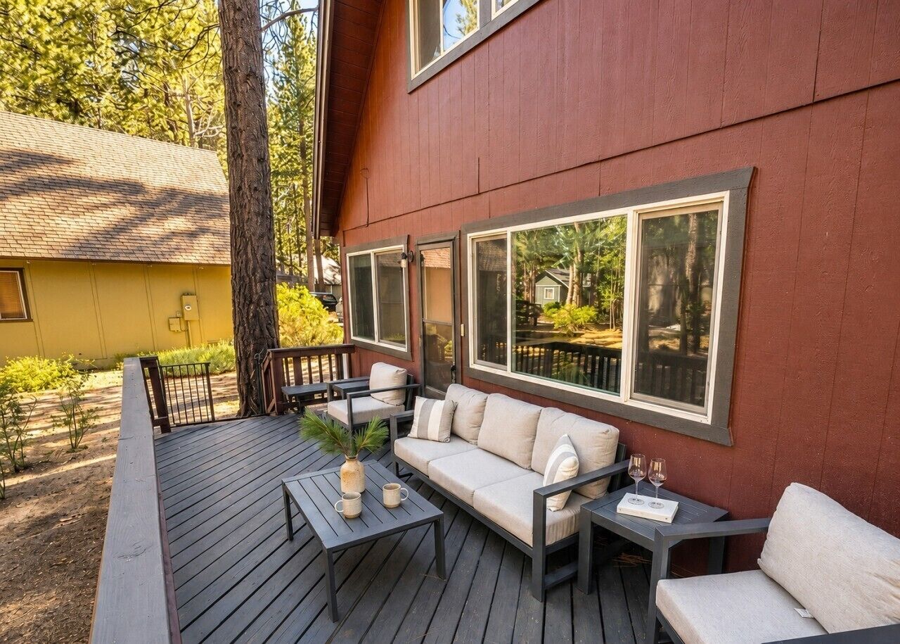 Una terraza con muebles de exterior, incluyendo un sofá y mesas, y ventanas amplias.