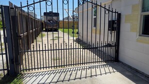 Uma entrada com portão que leva a um edifício com janela e porta.