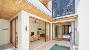 A modern interior with a pool, wooden ceiling, and a kitchen area. - Villa Aurora Canggu (Canggu)