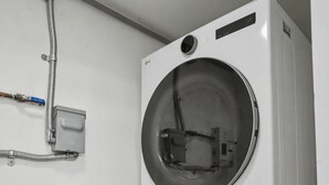 Dos lavadoras apiladas en una habitación con paredes blancas.