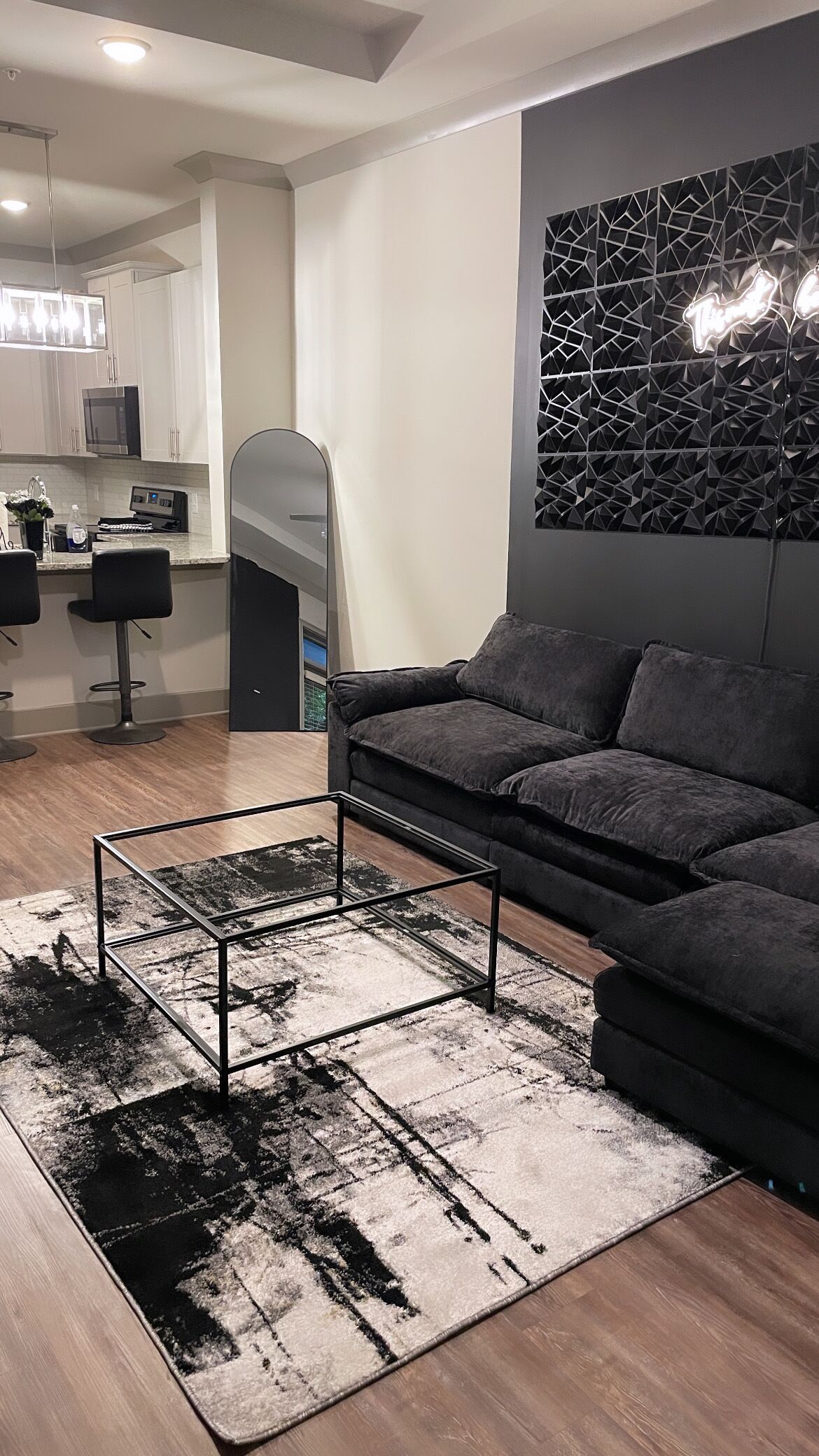 A modern living room with a sectional sofa, a coffee table, and a patterned rug.