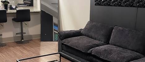 A modern living room with a sectional sofa, a coffee table, and a patterned rug.