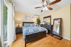 A bedroom with a bed, a dresser, a mirror, a ceiling fan, and artwork on the wall. - Charming 3BR Home Near NYC  Free Parking (JERSEY CITY)