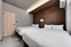 A hotel room with two beds, a wooden wardrobe, a bedside lamp, and a wall-mounted air conditioner. - THE AURUM (Asahikawa)