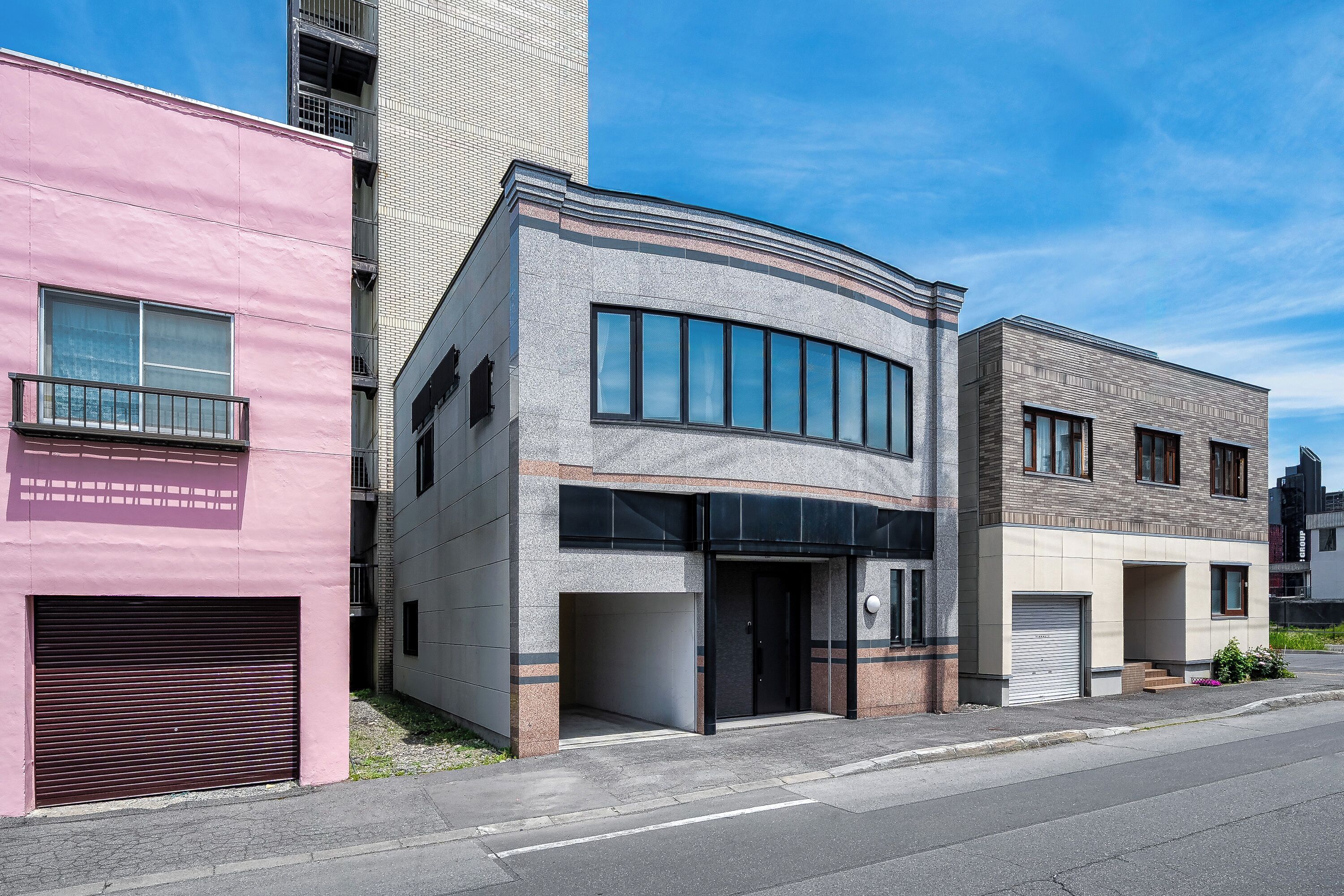 A row of modern buildings with large windows and a flat facade.