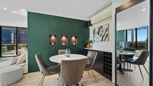 Un comedor moderno con una mesa redonda, sillas y vistas al exterior.