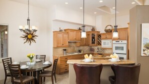 A modern kitchen with wooden cabinets, a central island, and pendant lighting. - Sedona Jewel | Panoramic Views, Patio, Hot Tub (Sedona)