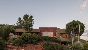 A modern house with a stone facade, large windows, and a well-maintained garden. - Sedona Jewel | Panoramic Views, Patio, Hot Tub (Sedona)