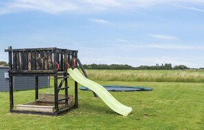 A playground with a slide and a climbing structure. - Cozy home in Stege with sauna (Stege)
