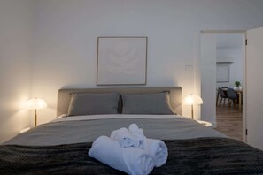 A neatly made bed with a patterned bedspread, two pillows, and a folded towel on the bed. - Comfortable Family Home in Newstead (Newstead)