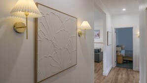 A hallway with a decorative wall panel and two wall-mounted lamps. - Comfortable Family Home in Newstead (Newstead)