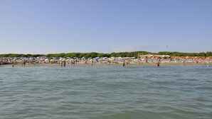 A beach with numerous umbrellas and people. - Holiday apartment mit Klimaanlage und Balkon (Jesolo)