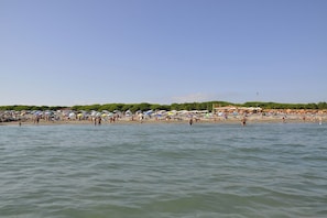 A beach with numerous umbrellas and people. - Holiday apartment mit Klimaanlage und Balkon (Jesolo)