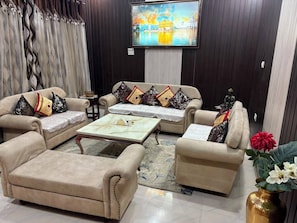 A living room with a sofa set, a coffee table, and a decorative vase.