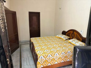 Une chambre à coucher avec un lit, une porte en bois et une armoire.