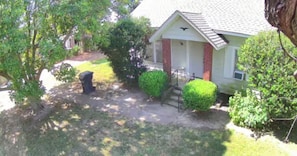 A residential house with a front porch, a small garden, and a pathway leading to the entrance.