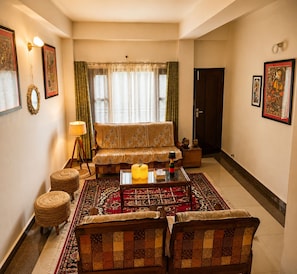A living room with a sofa, armchairs, a coffee table, and a patterned rug. - Adorable 3-bedroom luxury house with modular kitchen in peaceful Jutogh (Jutogh)