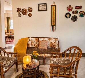A living room with a sofa, two chairs, a small table with a lamp, and decorative plates on the wall. - Adorable 3-bedroom luxury house with modular kitchen in peaceful Jutogh (Jutogh)