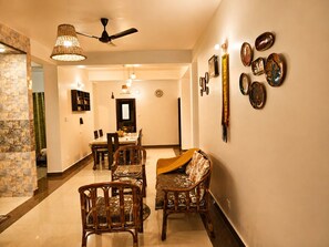 A dining area with a table, chairs, and a ceiling fan.