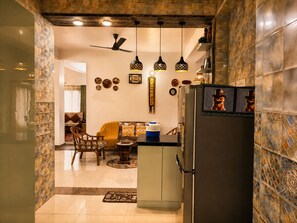 A kitchen with a refrigerator, pendant lights, and a dining area with chairs and a sofa. - Adorable 3-bedroom luxury house with modular kitchen in peaceful Jutogh (Jutogh)